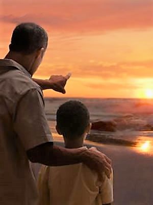 Father pointing at sun with son